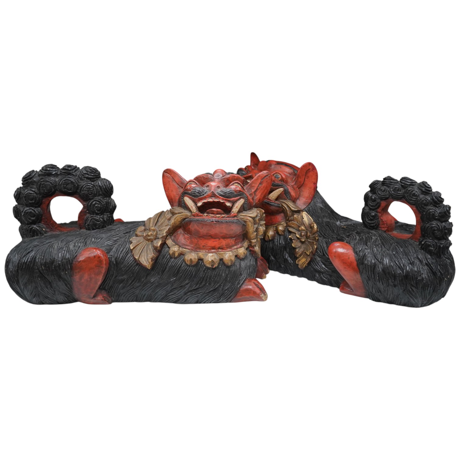 A pair of large Indonesian carved and painted wood lion dogs, 67cm wide.